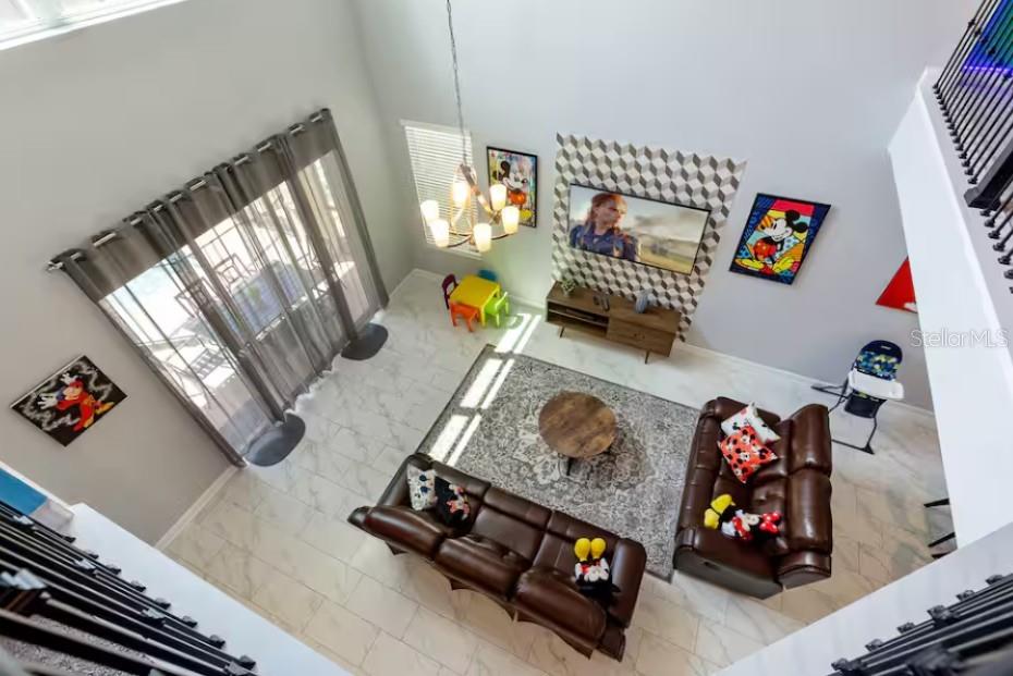 A high-angle view of a living room with tile floors, brown leather sofas, and decor — 4266 PARAGRAPH DRIVE, KISSIMMEE, FL
