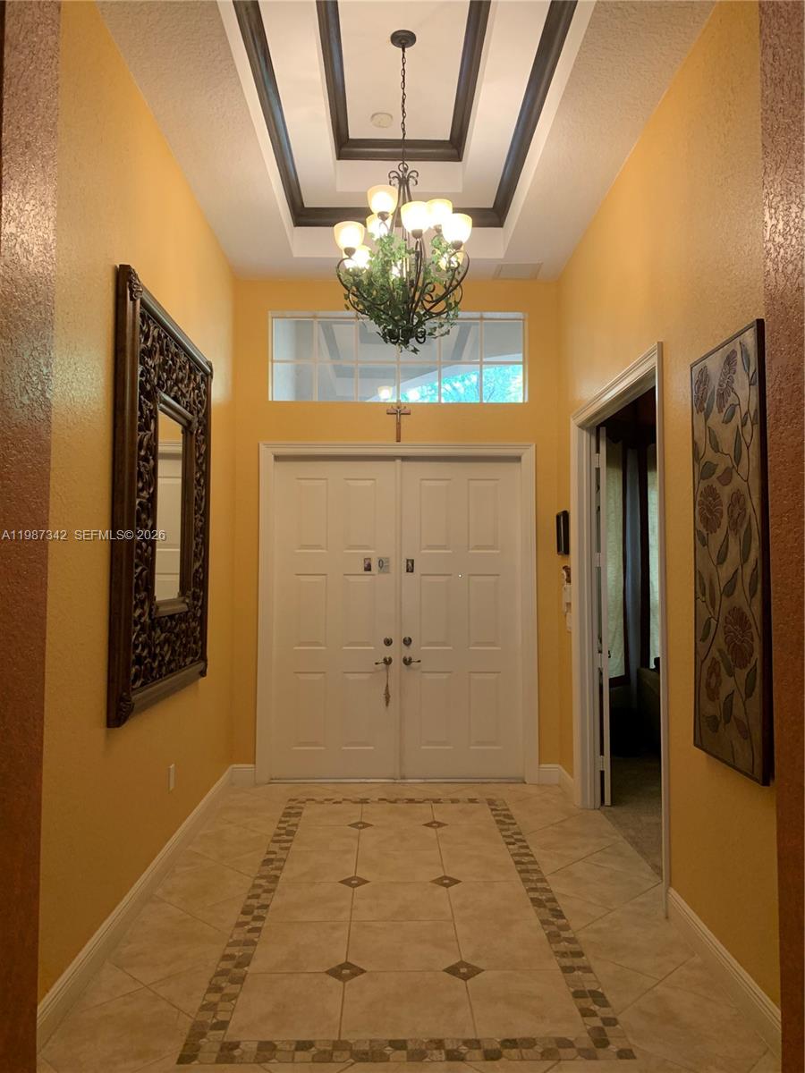 A foyer features a tray ceiling, a chandelier, tile flooring, and double entry doors — 4723 SW 195th Way, Miramar FL 33029, MIRAMAR, FL