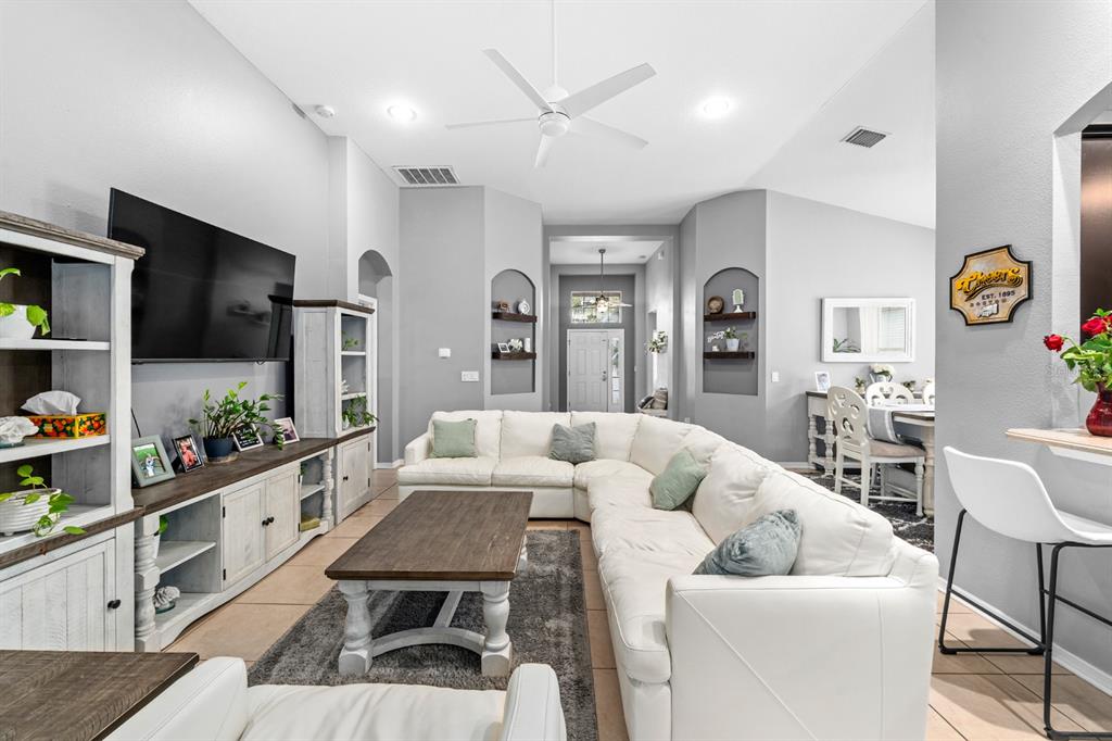 A living room features a white sectional sofa, a wooden coffee table, and built-in wall niches — 10207 AVELAR RIDGE DRIVE, RIVERVIEW, FL