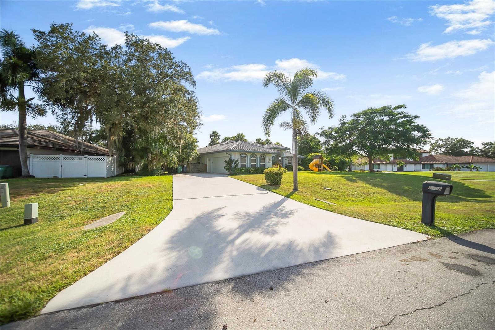 A single-story house with a concrete driveway, a palm tree, and a grassy front yard — 7305 E Elyse Circle, Port St. Lucie FL 34952, PORT ST. LUCIE, FL