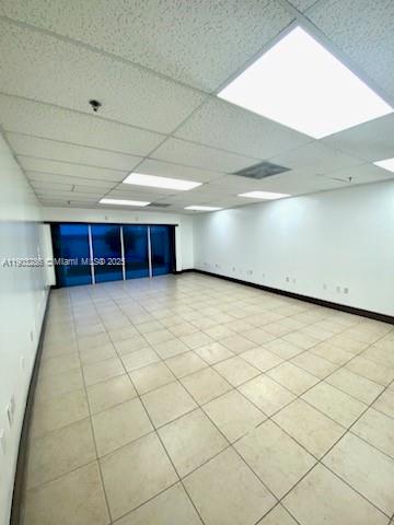 An empty office space with white walls, a drop ceiling, and light-colored tile flooring — 8202 NW 70th St # 6994, Medley FL 33195, MEDLEY, FL