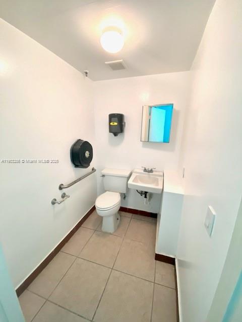 A small, white-walled accessible restroom features a toilet, a wall-mounted sink, and grab bars — 8202 NW 70th St # 6994, Medley FL 33195, MEDLEY, FL