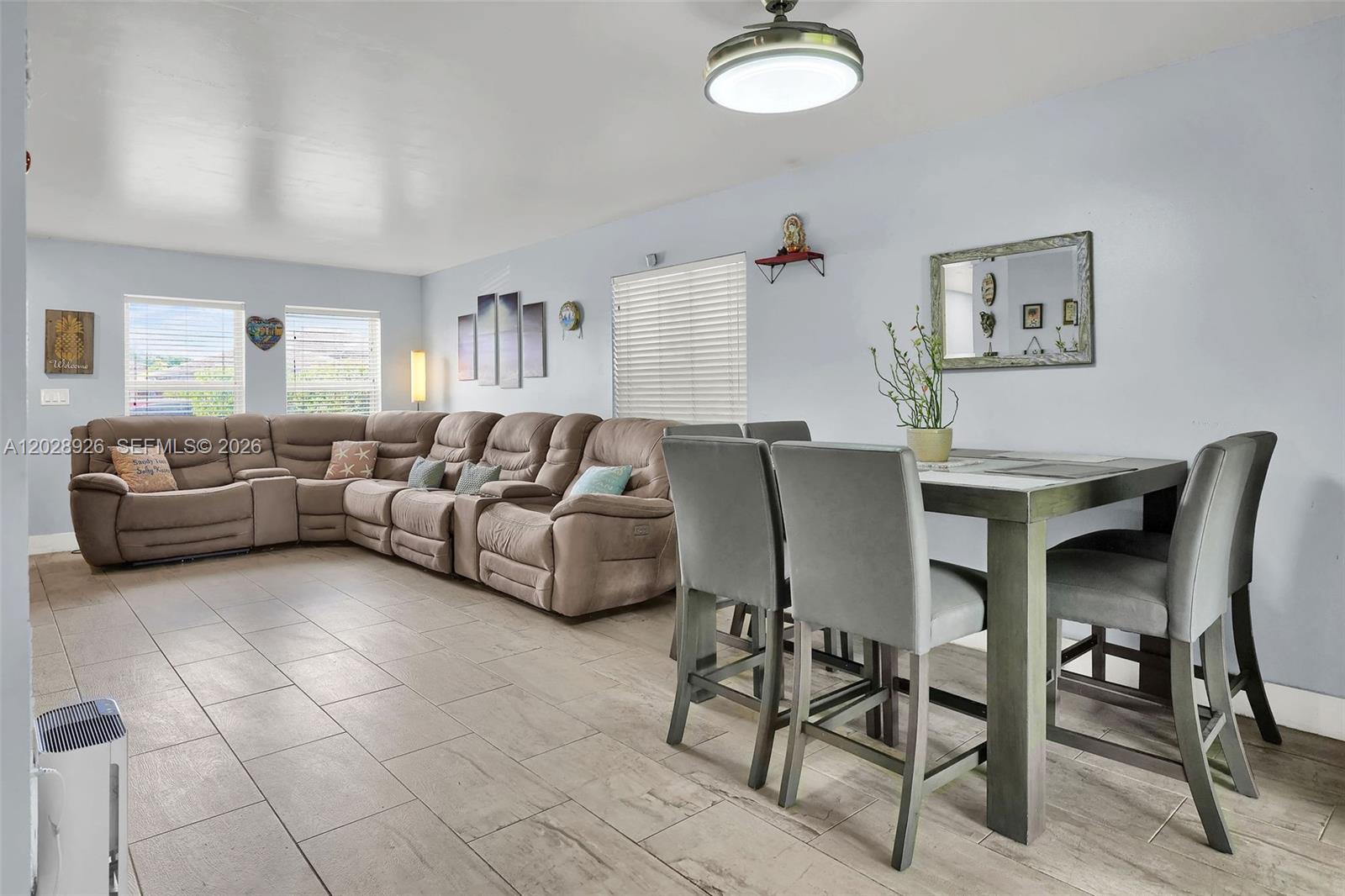 A living and dining area features a large sectional sofa, tile flooring, and gray chairs — 14244 SW 163rd Ter, Miami FL 33177, MIAMI, FL