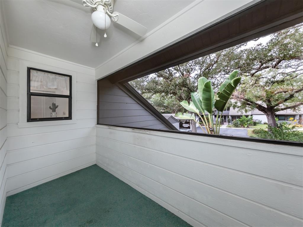 A screened-in porch features white horizontal siding, a green carpeted floor, and a ceiling fan — 3222 GOLDEN EAGLE LANE, SARASOTA, FL