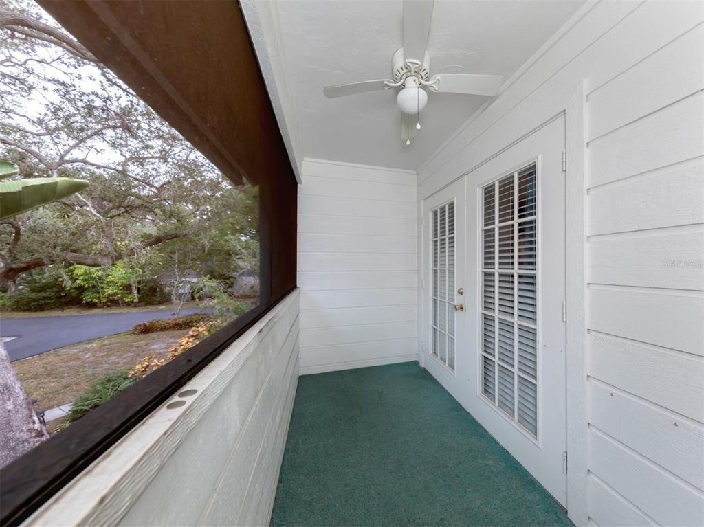 A screened-in porch features white horizontal siding, a ceiling fan, and double glass doors — 3222 GOLDEN EAGLE LANE, SARASOTA, FL