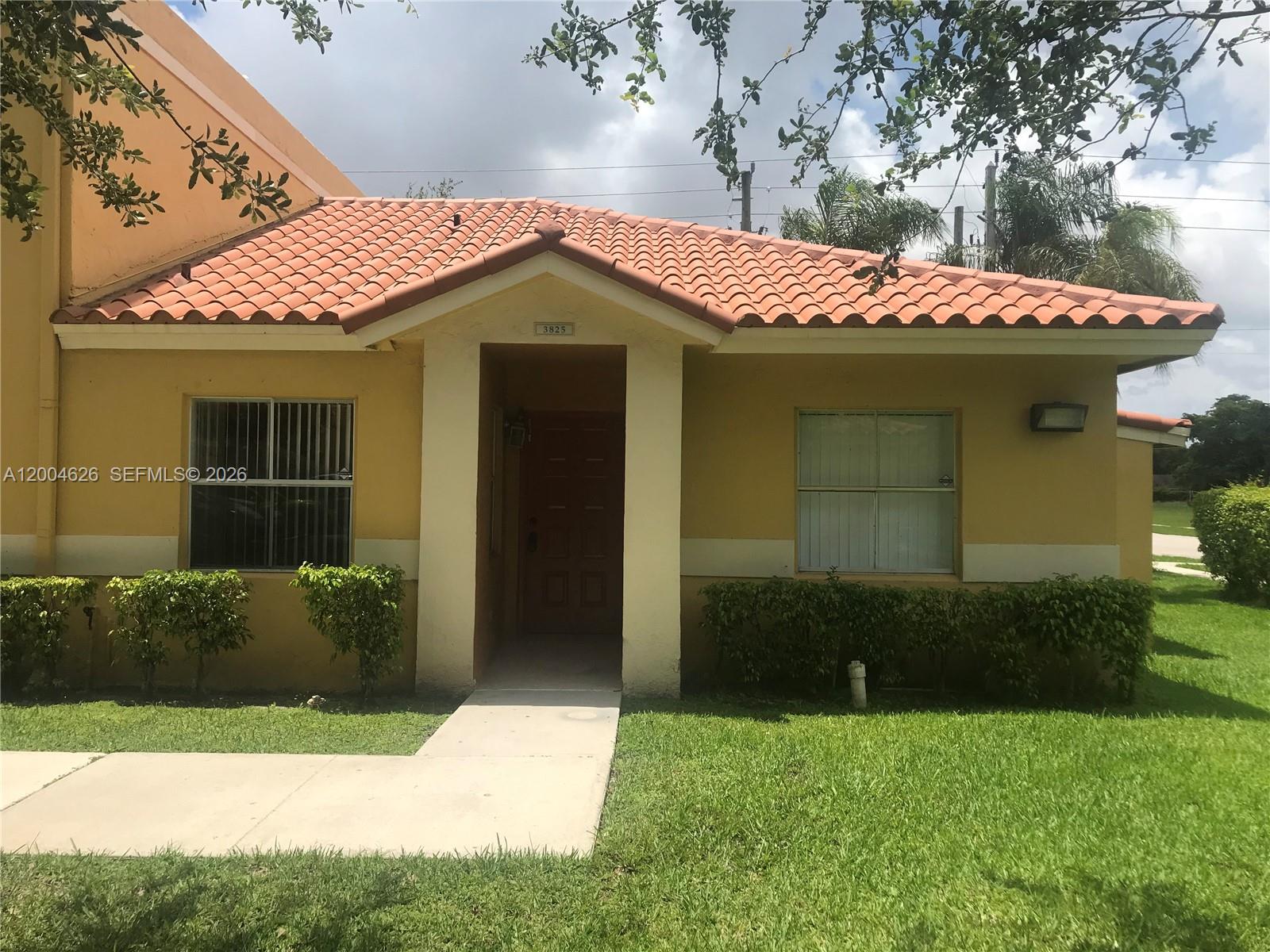 A yellow single-story house features a tiled roof and a concrete walkway leading to the entrance — 3825 NW 90th Ave # 3825, Sunrise FL 33351, SUNRISE, FL
