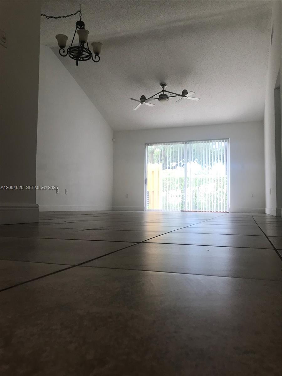 A living room with tile flooring, a vaulted ceiling, a ceiling fan, and sliding glass doors — 3825 NW 90th Ave # 3825, Sunrise FL 33351, SUNRISE, FL