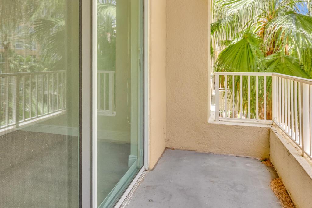 A small balcony with gray concrete flooring, beige walls, and white metal railings — 700 E Boynton Beach Boulevard # 407, Boynton Beach FL 33435, BOYNTON BEACH, FL