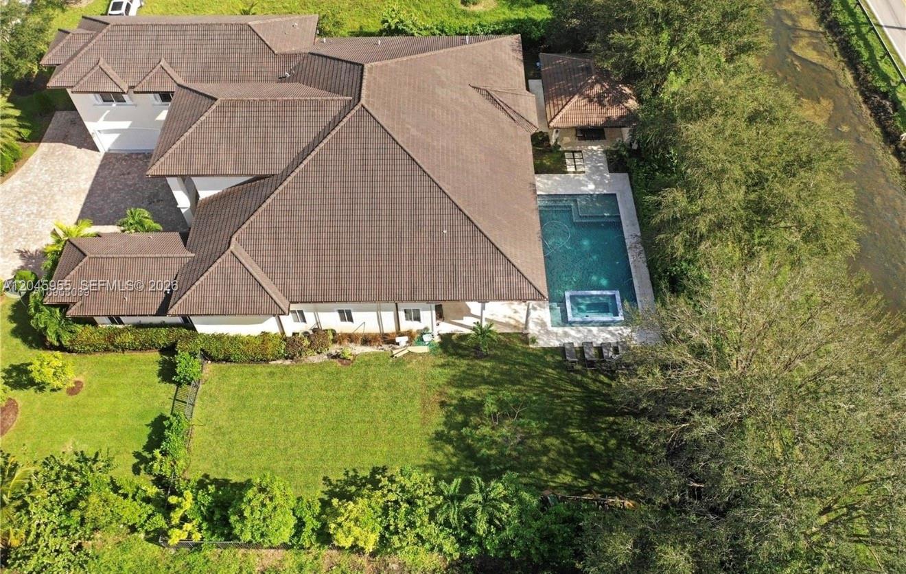 An aerial view shows a house with a brown tile roof, pool, and backyard — 12802 Grand Oaks Dr # 0, Davie FL 33330, DAVIE, FL