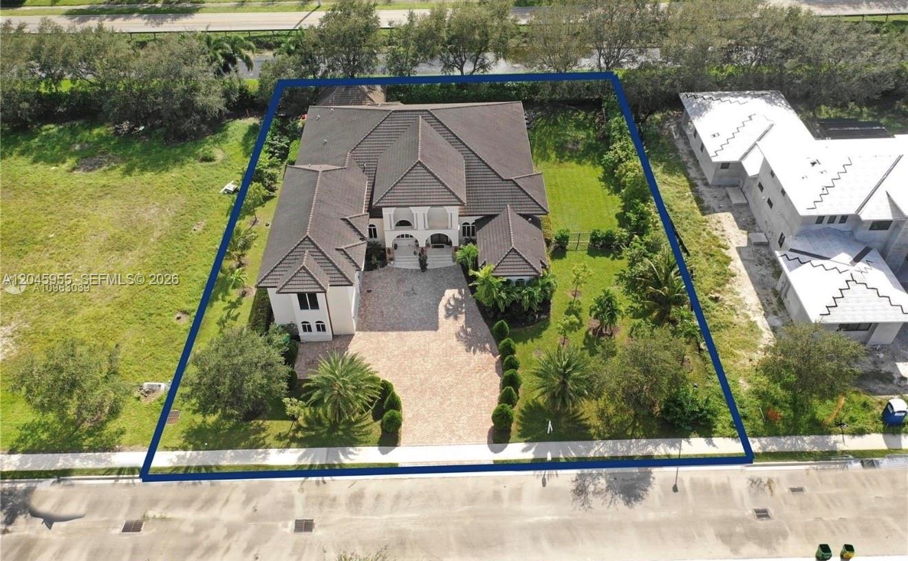 An aerial view shows a large house with a tiled roof and a brick driveway — 12802 Grand Oaks Dr # 0, Davie FL 33330, DAVIE, FL