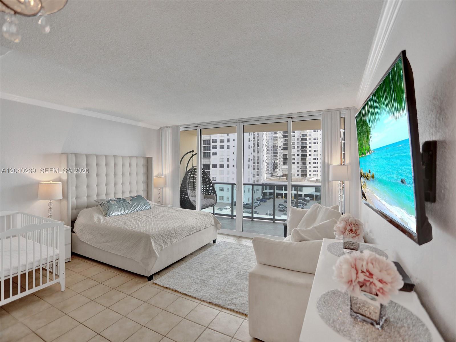 A bedroom features a tufted headboard, a crib, a sofa, and a balcony with city views — 2501 S Ocean Dr, Hollywood FL 33019, HOLLYWOOD, FL