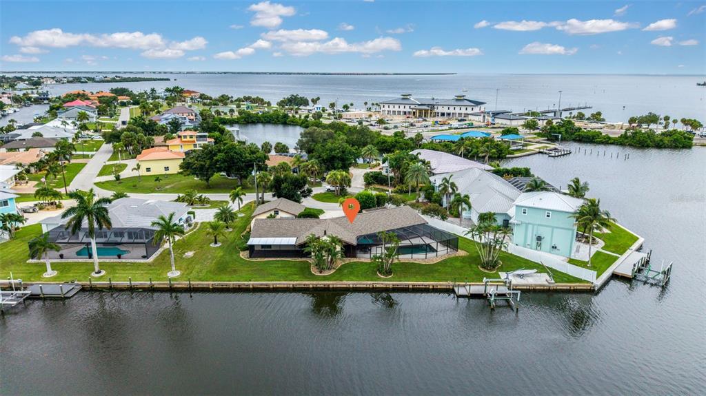 An aerial view shows a waterfront house with a screened pool and a private dock — 4589 COLLEEN STREET, PORT CHARLOTTE, FL