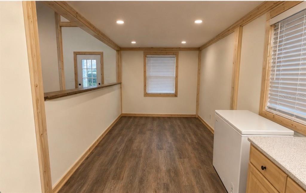 A room with wood-trimmed walls, recessed lighting, wood-look flooring, and a white chest freezer — 3830 COUNTY ROAD 547 N, DAVENPORT, FL