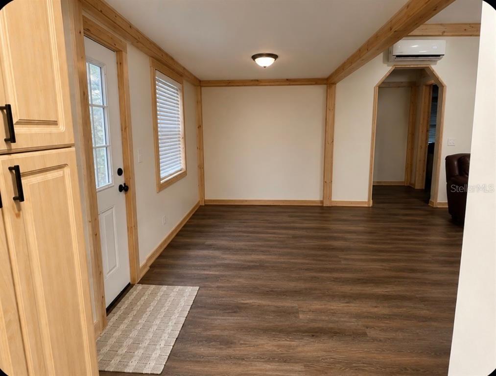A room with wood-look flooring, light wood trim, a white door, and a ceiling light — 3830 COUNTY ROAD 547 N, DAVENPORT, FL