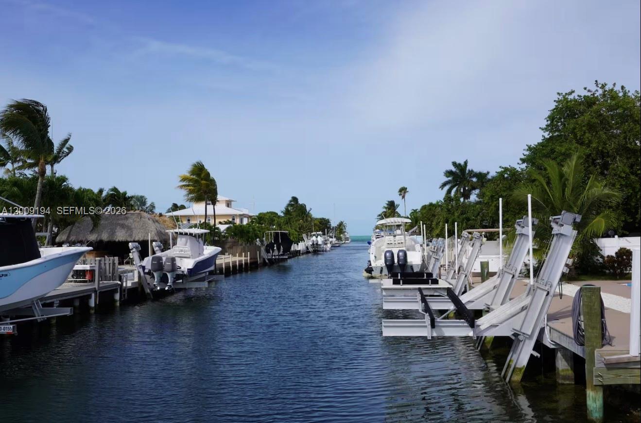 A canal view features multiple boats docked on lifts along both sides of the water — 2133 Yellowtail Dr, Marathon FL 33050, MARATHON, FL