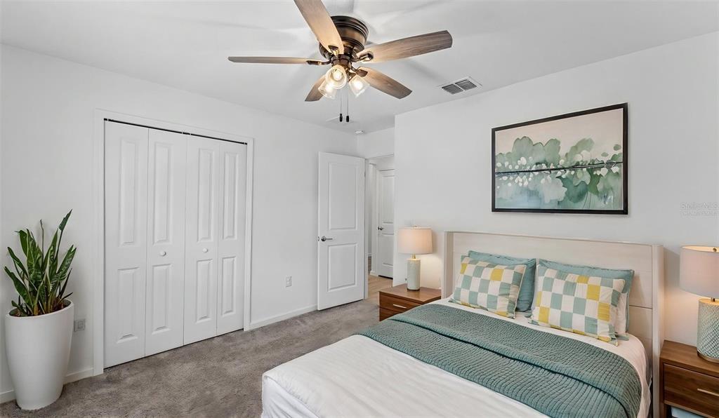 A bedroom features a ceiling fan, a bed with patterned pillows, and a white closet — 272 PERSHING STREET, BARTOW, FL