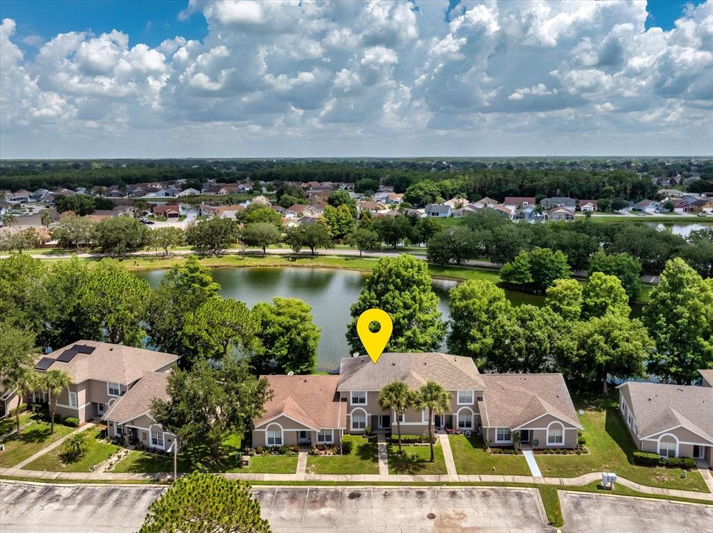 An aerial view shows a row of townhouses with a pond and trees behind them — 2321 WATER VIEW LOOP, KISSIMMEE, FL