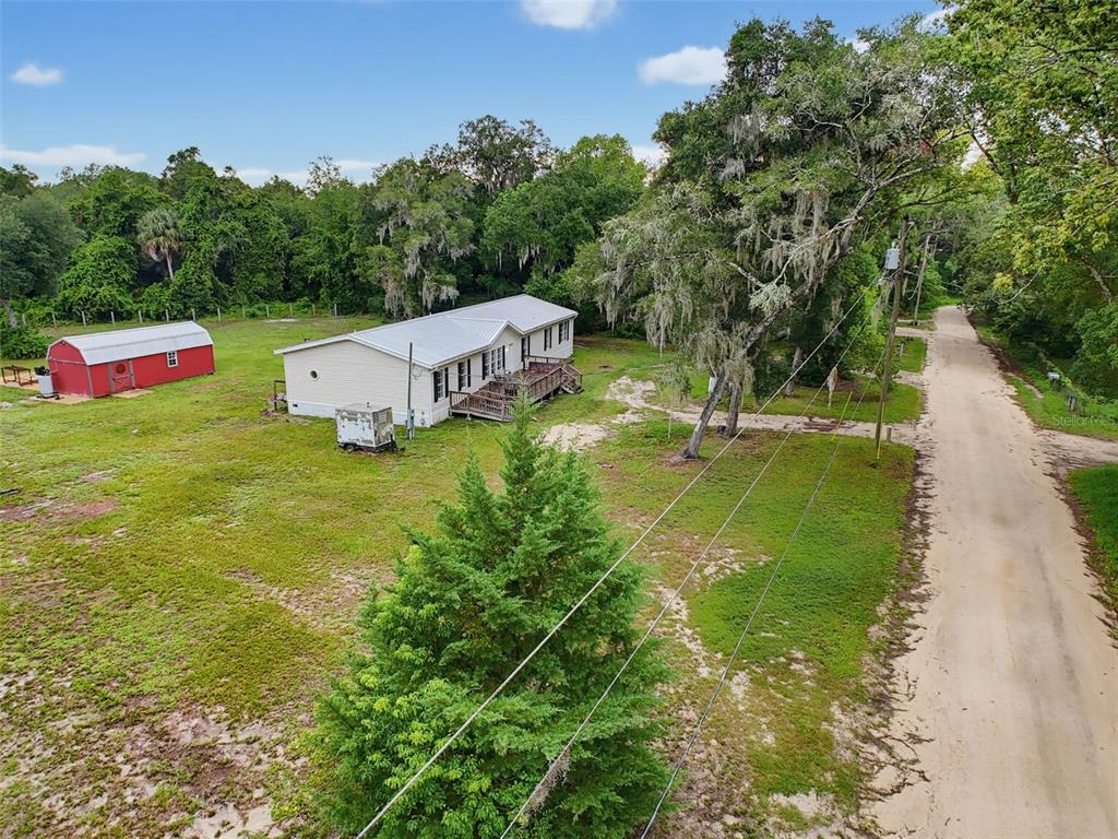 An aerial view shows a single-story house, a red shed, and a dirt road — 14080 SE 122ND LANE ROAD, OCKLAWAHA, FL