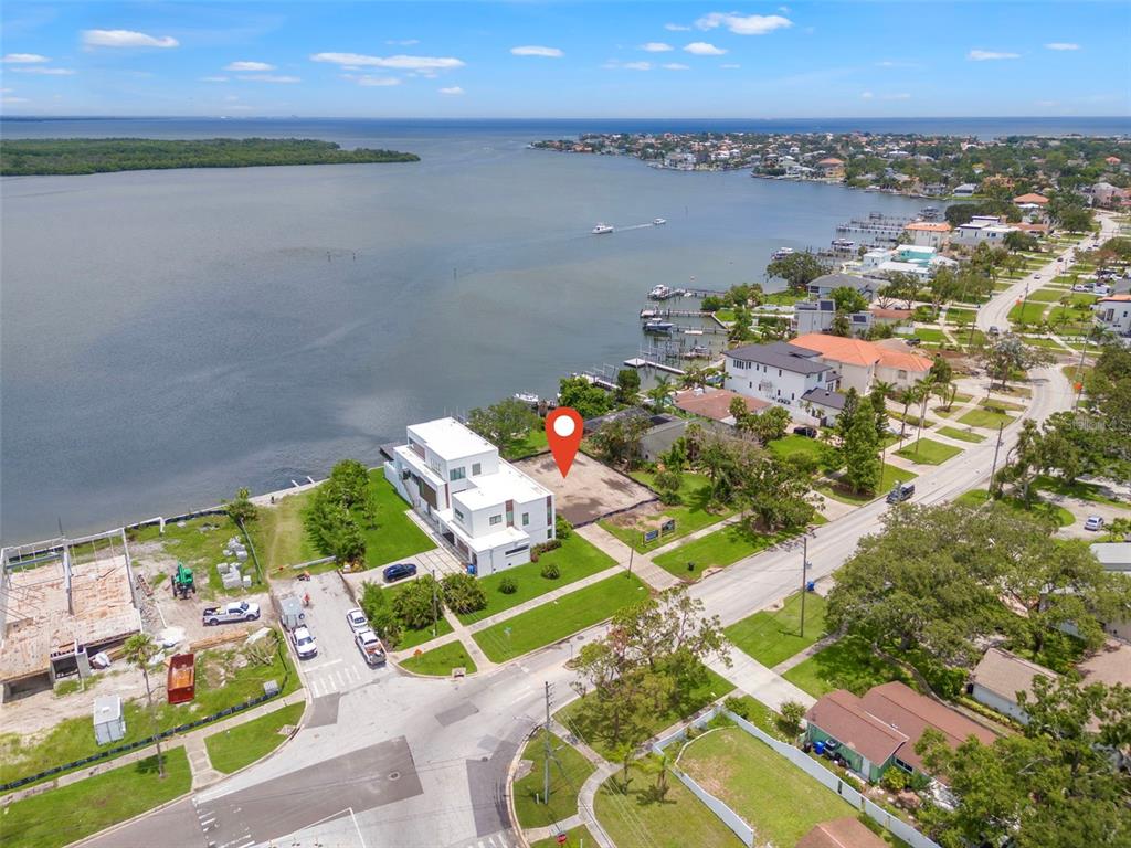 An aerial view shows a modern waterfront house with a pool and private boat dock — 6151 BAYOU GRANDE BOULEVARD NE, ST PETERSBURG, FL