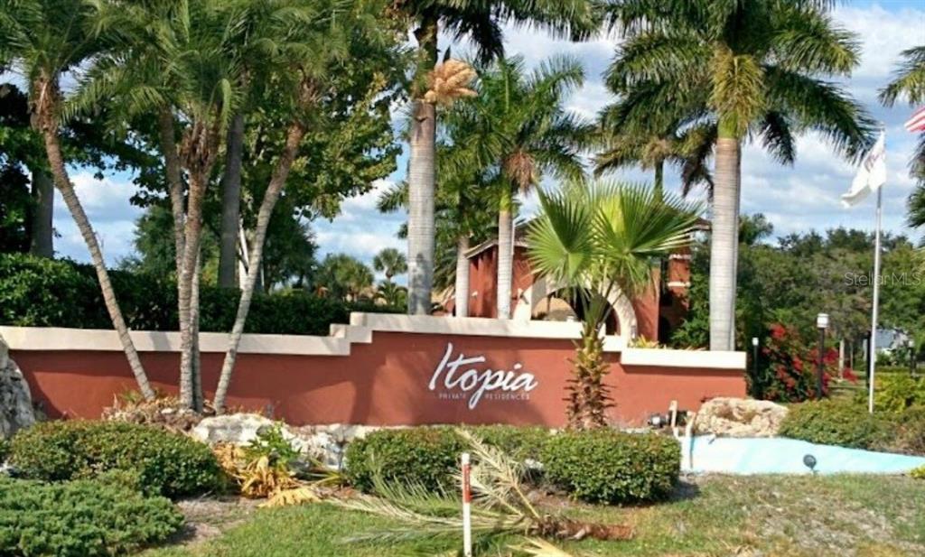 A terracotta-colored sign for Itopia Private Residences stands in front of palm trees and landscaping — 10263 GANDY BOULEVARD N UNIT 403, ST PETERSBURG, FL