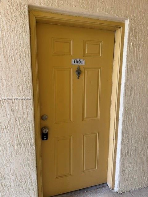A yellow door with the number 1401 is set into a textured beige wall — 1249 SW 46th Ave # 1401, Pompano Beach FL 33069, POMPANO BEACH, FL