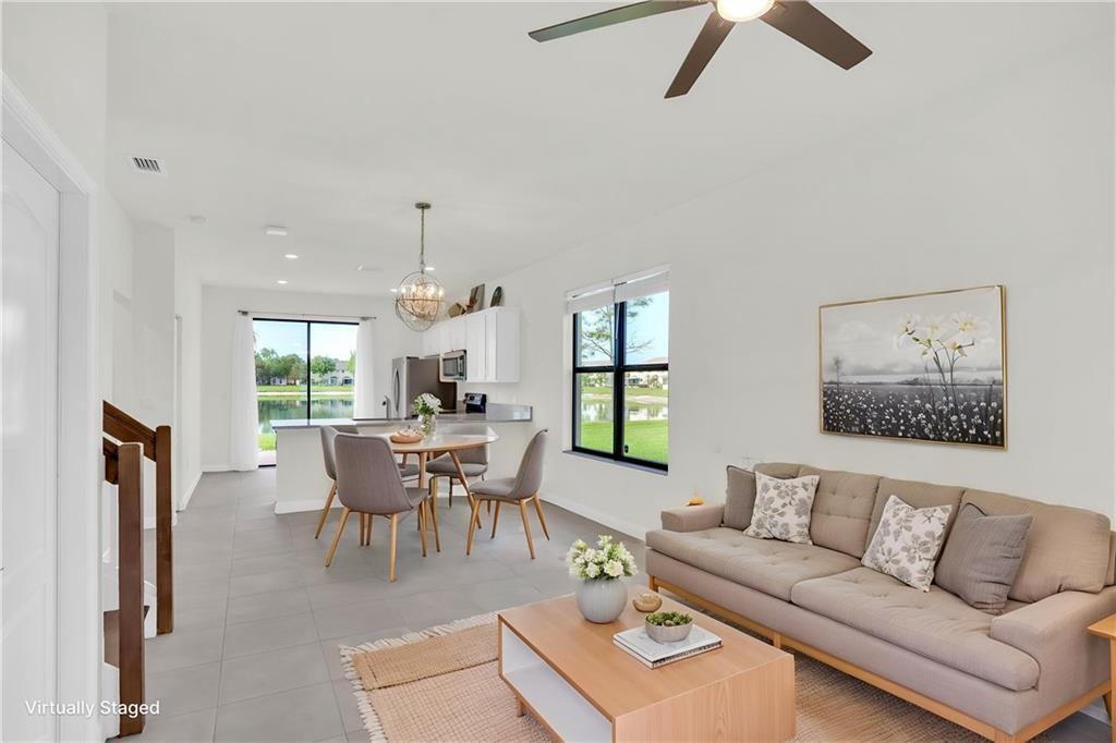 This open-concept living and dining area features tile flooring, a kitchen, and water views — VERO BEACH, FL