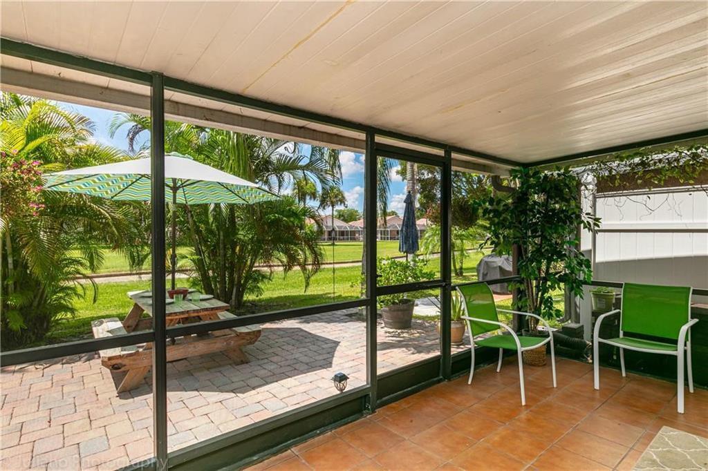 A screened-in patio with tile flooring overlooks a paved outdoor area with a picnic table — 7610 Pinewalk Drive S # 128, Margate FL 33063, MARGATE, FL