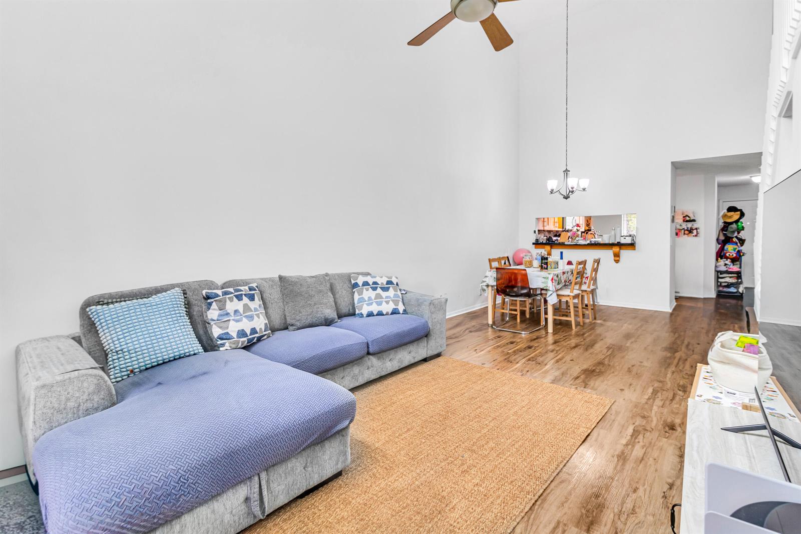 A living room with a gray sectional sofa, a dining area, and wood-look flooring — 7610 Pinewalk Drive S # 128, Margate FL 33063, MARGATE, FL