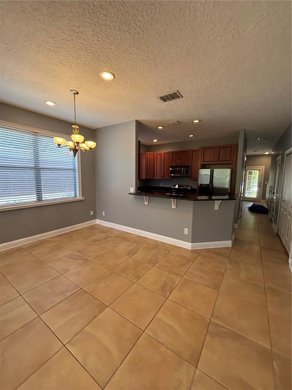 A dining area with tile floors leads to an open kitchen with dark wood cabinets — 2505 KILGORE STREET, ORLANDO, FL