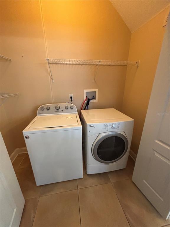 A laundry room features a white top-load washer and a front-load dryer on tile flooring — 2505 KILGORE STREET, ORLANDO, FL