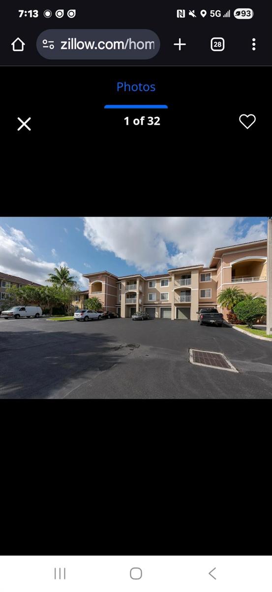A multi-story apartment building with tan stucco walls and a parking lot in front — 6556 Emerald Dunes Drive # 207, West Palm Beach FL 33411, WEST PALM BEACH, FL