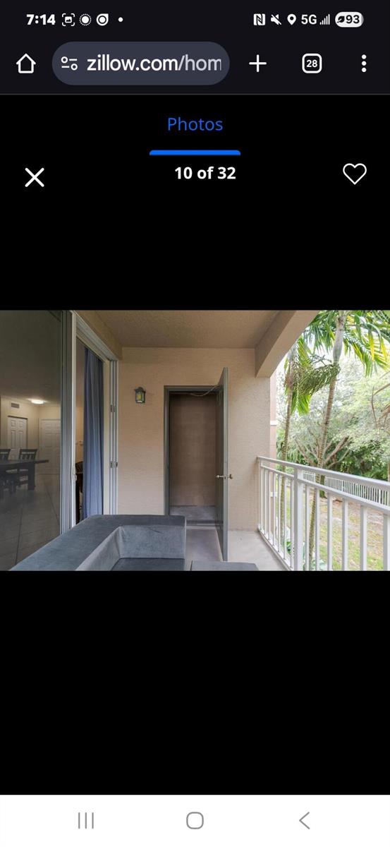 A balcony features a storage closet, a sliding glass door, and a white metal railing — 6556 Emerald Dunes Drive # 207, West Palm Beach FL 33411, WEST PALM BEACH, FL