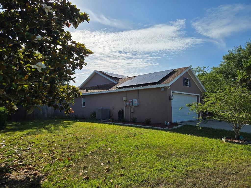 A side view of a house with solar panels on the roof and a garage — 4199 BANBURY CIRCLE, PARRISH, FL