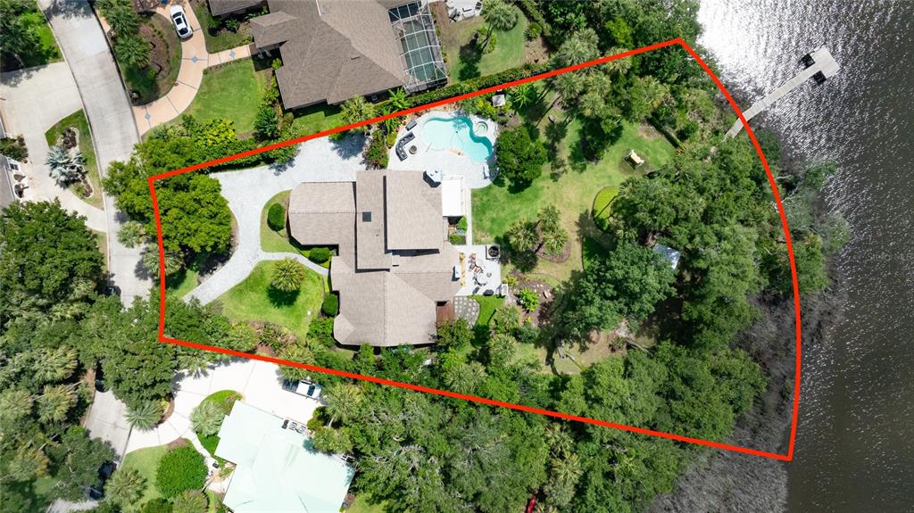An aerial view shows a house with a pool and large yard bordering a river — 6315 PALMAS BAY CIRCLE, PORT ORANGE, FL