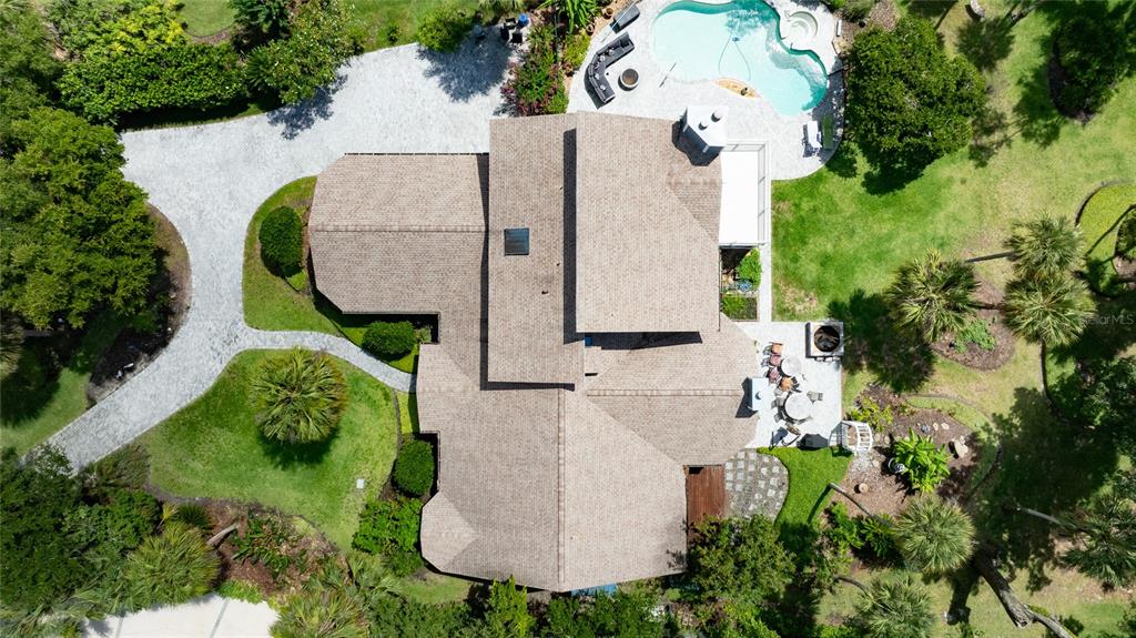 An aerial view shows a house with a shingled roof, a pool, and landscaped grounds — 6315 PALMAS BAY CIRCLE, PORT ORANGE, FL