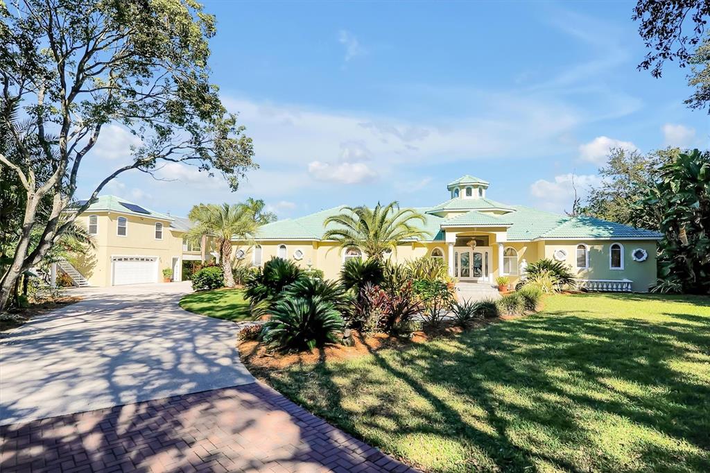 A large yellow house with a green tile roof and a paved driveway — 4209 LAKE LOCKHART DRIVE, ORLANDO, FL