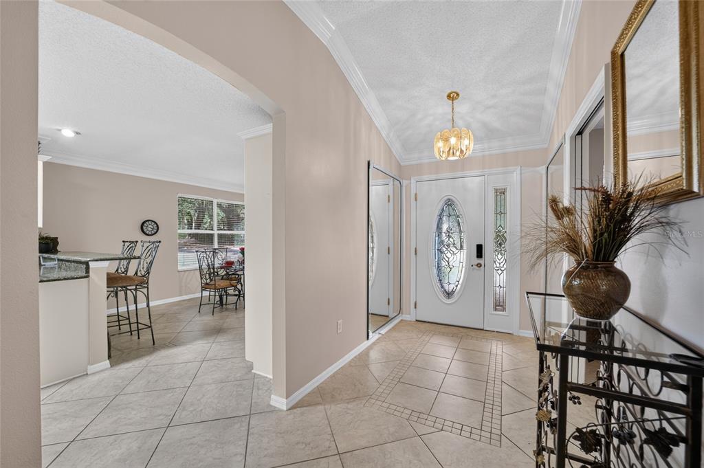 A tiled entryway features a white front door with a decorative glass oval insert — 1230 DESILVA STREET, THE VILLAGES, FL