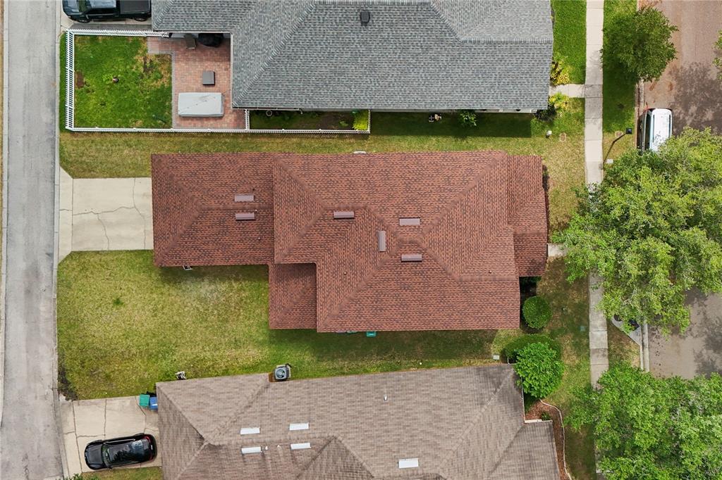 An aerial view shows the brown shingled roof of a house surrounded by neighboring properties — 13619 PHOENIX DRIVE, ORLANDO, FL