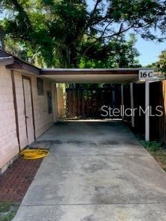A concrete driveway leads to a covered carport attached to the side of a building — 16 W LAUREL OAK DRIVE UNIT C, EUSTIS, FL