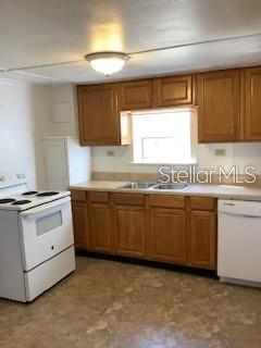 A kitchen features wood cabinets, white appliances, and a window above the sink — 16 W LAUREL OAK DRIVE UNIT C, EUSTIS, FL