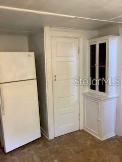 A white refrigerator stands next to a white door and a small white cabinet — 16 W LAUREL OAK DRIVE UNIT C, EUSTIS, FL