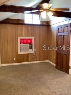 A room with wood-paneled walls, a window air conditioner, a ceiling fan, and a door — 16 W LAUREL OAK DRIVE UNIT C, EUSTIS, FL