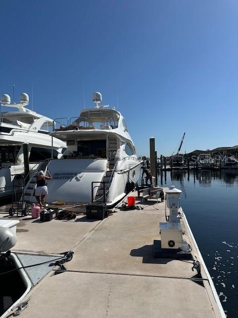 A large white yacht is docked at a concrete pier on a sunny day — 101 RIVIERA DUNES WAY UNIT S 34, PALMETTO, FL