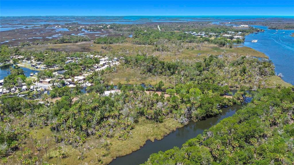An aerial view shows a winding river flowing through a forested landscape near a campground — 11441 W BROWN PELICAN PATH, CRYSTAL RIVER, FL