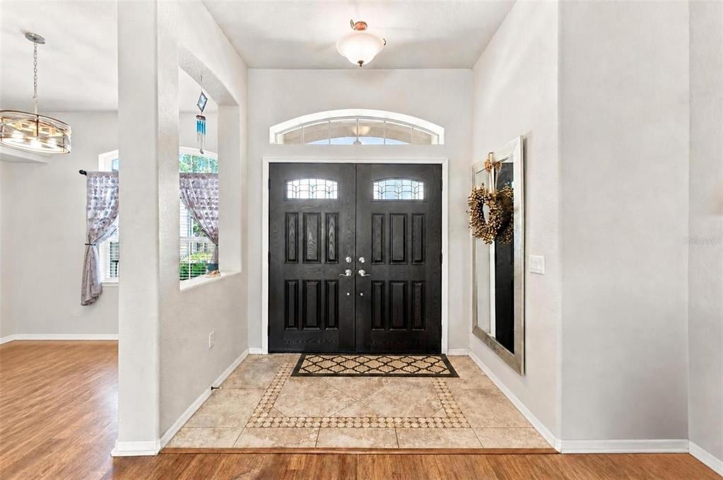 An entryway features a double front door, tile flooring, and a large wall mirror — 5287 SLATER ROAD, SPRING HILL, FL