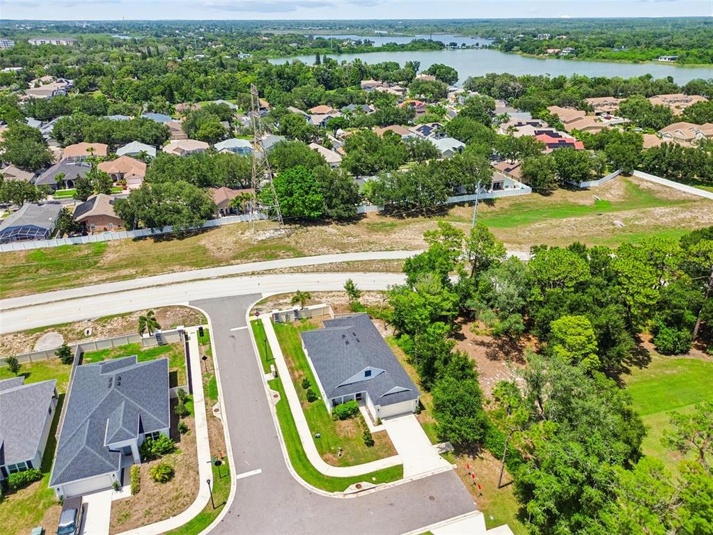 An aerial view shows two suburban houses with dark roofs situated on a cul-de-sac — 283 SAND CRANE WAY, TARPON SPRINGS, FL