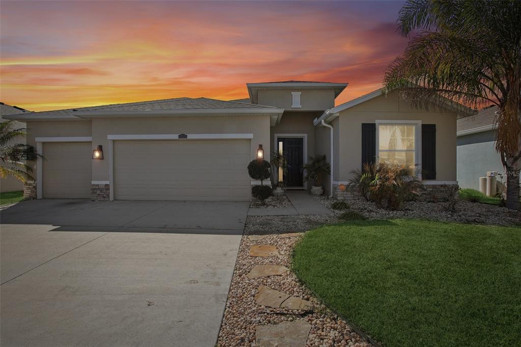 The backyard features a stone fire pit, a paved patio, and a tan stucco house exterior — 10747 LAXER CAY LOOP, SAN ANTONIO, FL
