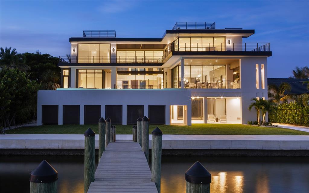 A modern multi-story waterfront home with a private dock, swimming pool, and large glass windows — 388 S SHORE DRIVE, SARASOTA, FL