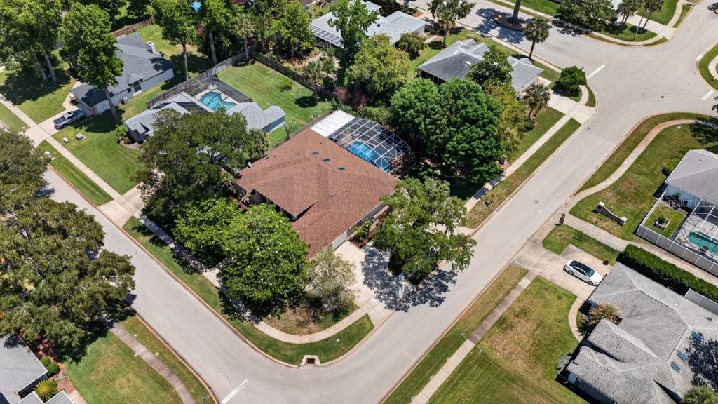 An aerial view shows a residential corner lot with a house featuring a screened pool — 941 GEORGE HECKER DRIVE, SOUTH DAYTONA, FL