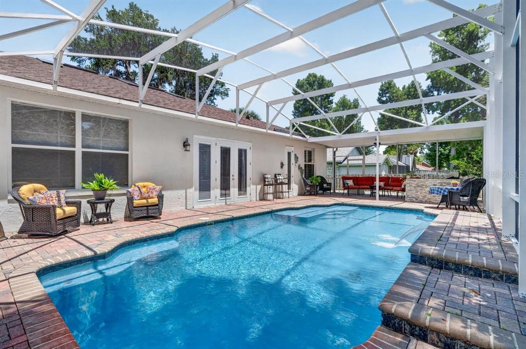 A screened-in patio features a swimming pool, brick pavers, and outdoor seating areas — 941 GEORGE HECKER DRIVE, SOUTH DAYTONA, FL